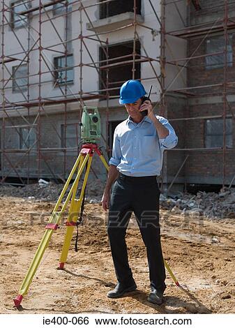 Engineer with theodolite and walkie talkie View Large Photo Image Stock Photograph - Engineer with theodolite and walkie talkie. Fotosearch