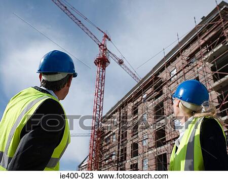Stock Image - Engineers looking at crane. Fotosearch