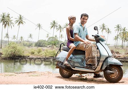 Couple on a moped View Large Photo Image Stock Image - Couple on a moped. Fotosearch