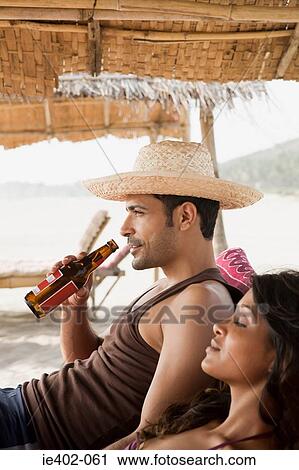 Couple relaxing at the beach View Large Photo Image Stock Image - Couple relaxing at the beach. Fotosearch
