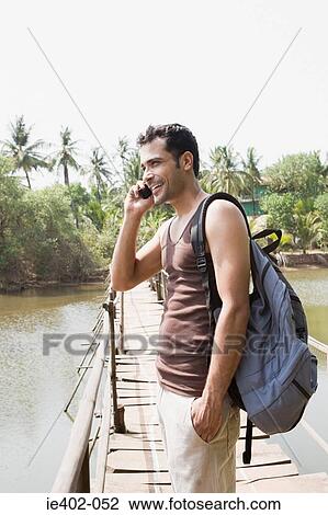 Man on bridge on cellphone View Large Photo Image Stock Image - Man on bridge on cellphone. Fotosearch