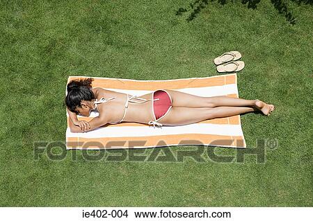 Picture - Young woman sunbathing. Fotosearch