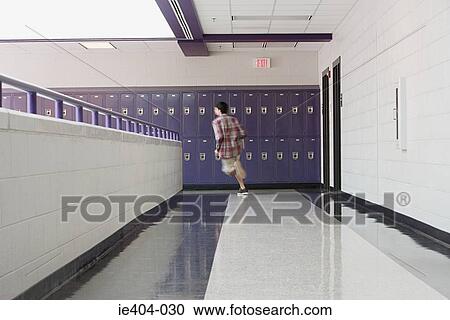 Stock Image - A male high school student running in a corridor. Fotosearch