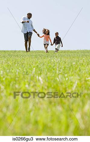Stock Image - Father and children in field. Fotosearch