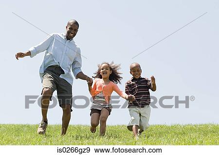 Stock Photo - Father and children in field. Fotosearch