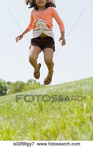 Stock Photo - Girl jumping in field. Fotosearch