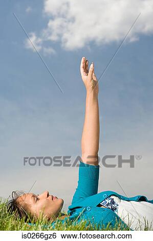 Stock Photograph - Woman lying down with arm raised. Fotosearch