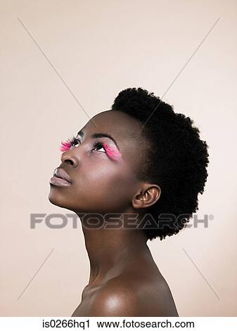 Stock Image - A woman wearing pink false eyelashes. Fotosearch