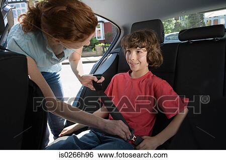 Stock Photograph - A mother fastening her sons seatbelt. Fotosearch