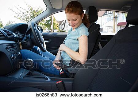 A woman fastening a seatbelt View Large Photo Image Stock Image - A woman fastening a seatbelt. Fotosearch