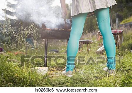 Woman barbecuing food View Large Photo Image Stock Photograph - Woman barbecuing food. Fotosearch