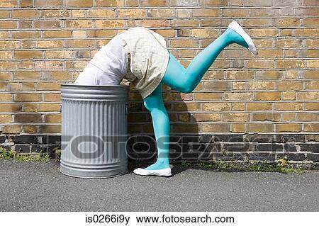 Woman looking in a dustbin View Large Photo Image Stock Photo - Woman looking in a dustbin. Fotosearch