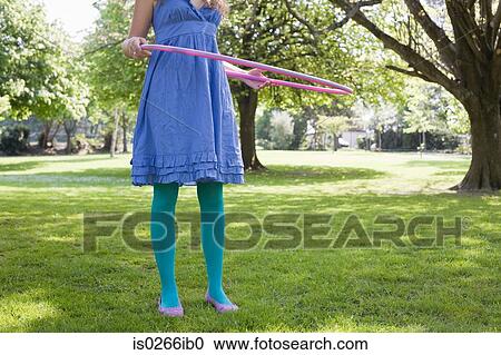 Woman playing with a hula hoop View Large Photo Image Stock Image - Woman playing with a hula hoop. Fotosearch