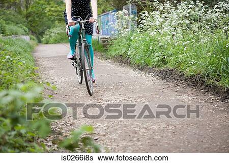 Woman riding a bicycle View Large Photo Image Stock Photograph - Woman riding a bicycle. Fotosearch