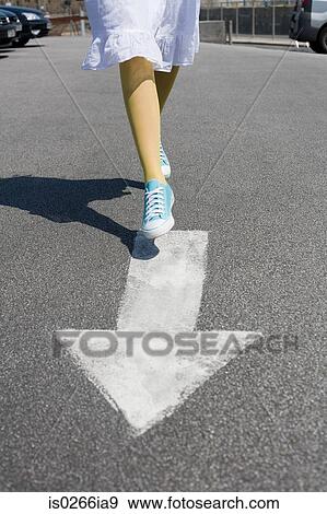 Woman running on a direction arrow View Large Photo Image Stock Photo - Woman running on a direction arrow. Fotosearch