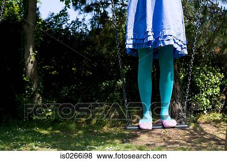 Woman standing on a swing View Large Photo Image Stock Photo - Woman standing on a swing. Fotosearch