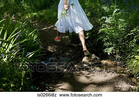 Stock Photo - Woman walking in a garden. Fotosearch