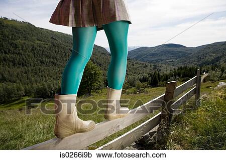 Woman walking on a wooden fence View Large Photo Image Stock Image - Woman walking on a wooden fence. Fotosearch