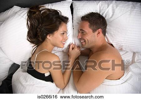 A couple lying in bed face to face View Large Photo Image Stock Photograph - A couple lying in bed face to face. Fotosearch