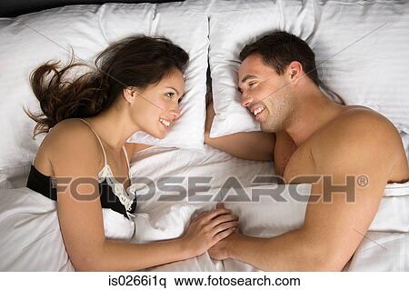 A couple lying in bed face to face View Large Photo Image Stock Photography - A couple lying in bed face to face. Fotosearch