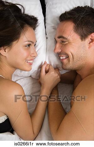 A couple lying in bed face to face View Large Photo Image Stock Photography - A couple lying in bed face to face. Fotosearch