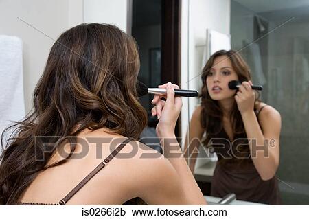 Stock Image - A woman applying make up. Fotosearch
