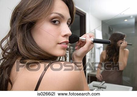 Stock Image - A woman applying make up. Fotosearch