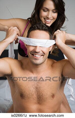 A woman blindfolding a man View Large Photo Image Stock Photo - A woman blindfolding a man. Fotosearch