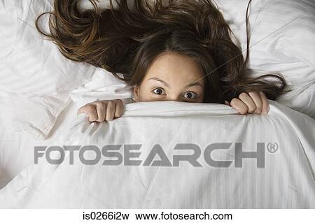 A woman hiding under a duvet View Large Photo Image Stock Photo - A woman hiding under a duvet. Fotosearch