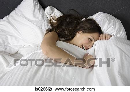 A woman hiding under a duvet View Large Photo Image Stock Photograph - A woman hiding under a duvet. Fotosearch