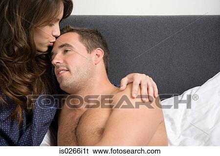 Stock Photograph - A woman kissing a man on the forehead. Fotosearch