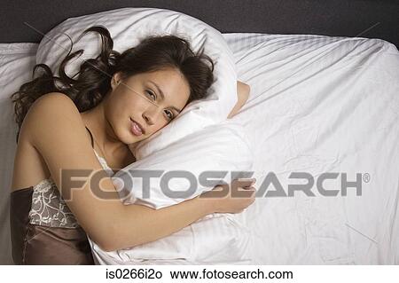 Picture - A woman lying on a bed. Fotosearch