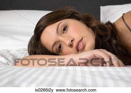 A woman lying on a bed View Large Photo Image Stock Photo - A woman lying on a bed. Fotosearch