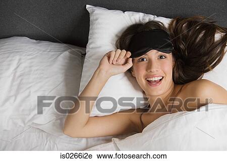 A woman wearing an eye mask in bed View Large Photo Image Stock Image - A woman wearing an eye mask in bed. Fotosearch