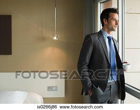 A businessman looking out of a window View Large Photo Image Stock Photograph - A businessman looking out of a window. Fotosearch