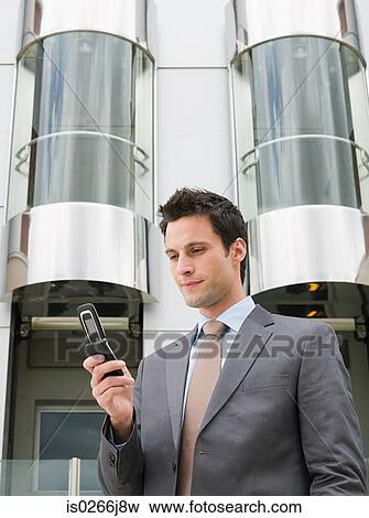 Stock Photo - A businessman using a cell phone. Fotosearch