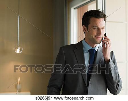 A businessman using a cell phone View Large Photo Image Stock Photography - A businessman using a cell phone. Fotosearch