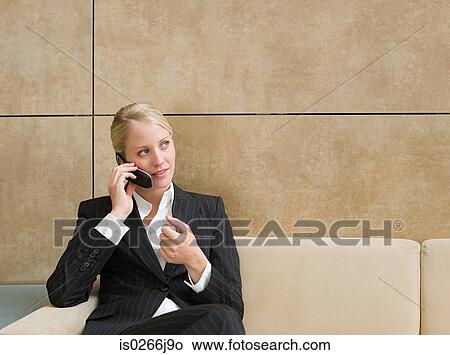 Picture - A businesswoman using a cell phone. Fotosearch