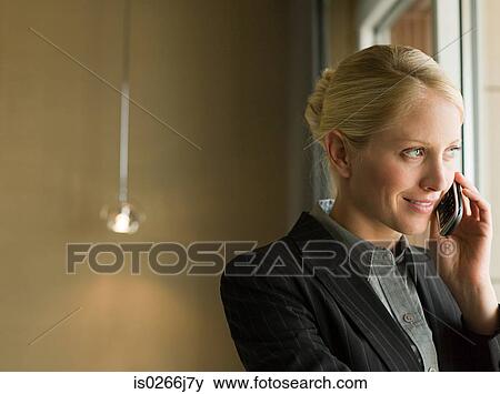 Stock Photo - A businesswoman using a cell phone. Fotosearch