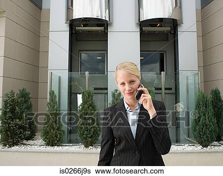 Stock Photograph - A businesswoman using a cell phone. Fotosearch