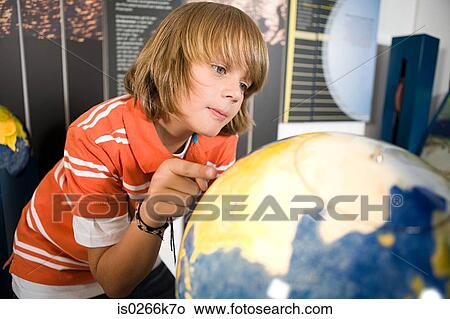 Boy looking at a globe View Large Photo Image Picture - Boy looking at a globe. Fotosearch