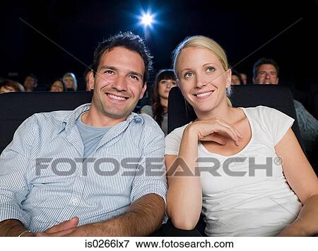 Stock Photo - A couple watching a movie. Fotosearch