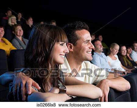 Stock Photo - A couple watching a movie. Fotosearch