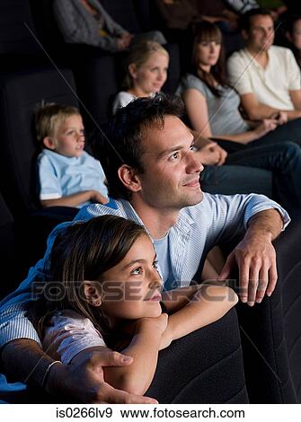 Stock Photo - Father and daughter watching a movie. Fotosearch