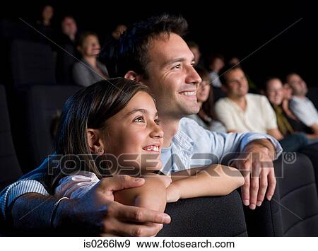Father and daughter watching a movie View Large Photo Image Stock Photo - Father and daughter watching a movie. Fotosearch