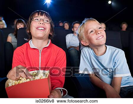 Stock Photo - Two boys watching a movie. Fotosearch