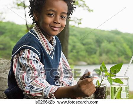 Stock Image - A boy doing an experiment on a plant. Fotosearch
