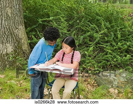 Stock Photo - A boy helping his friend with schoolwork. Fotosearch