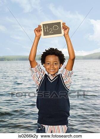 A boy holding a blackboard with the symbol for water View Large Photo Image Stock Photo - A boy holding a blackboard with the symbol for water. Fotosearch