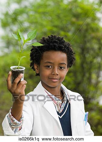 A boy holding a plant in a volumetric flask View Large Photo Image Stock Photography - A boy holding a plant in a volumetric flask. Fotosearch